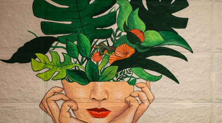 Vrouw verzorgt planten voor een kleurrijke muurschildering in een werkruimte